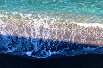 Top view of the turquoise sea surrounded by a deserted beach