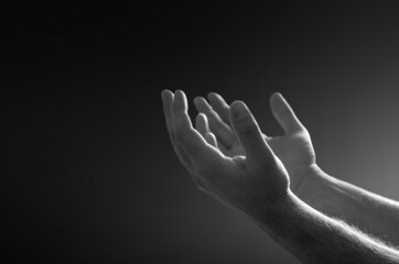 Fototapeta premium Praying hands with faith in religion and belief in God on dark background. Power of hope, love and devotion.