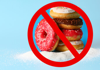 Sweet donuts and prohibition sign on light blue background. No sugar