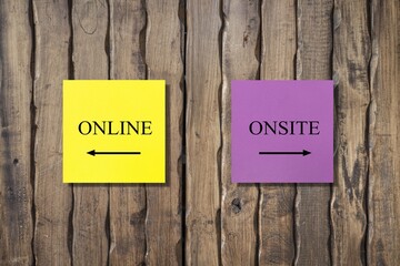 Yellow and pink note on wall with text and direction to ONLINE and ONSITE, concept of education and work in pandemic lockdow