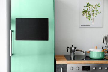Modern refrigerator with chalkboard and stove in kitchen