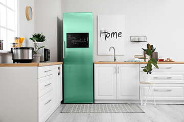 Stylish interior of modern kitchen with big turquoise refrigerator