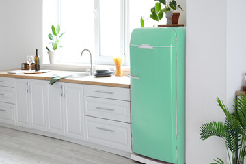 Stylish vintage refrigerator in interior of light kitchen