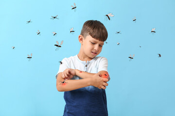 Little boy scratching himself because of mosquito bites on blue background