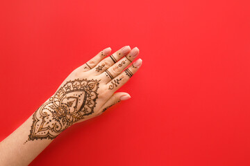 Female hand with beautiful henna tattoo on color background