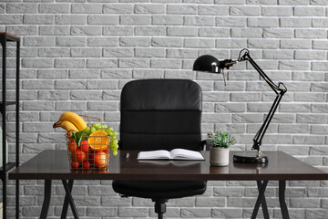 Modern workplace with fruit basket on table