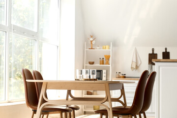 Tray with empty glasses on dining table in light room