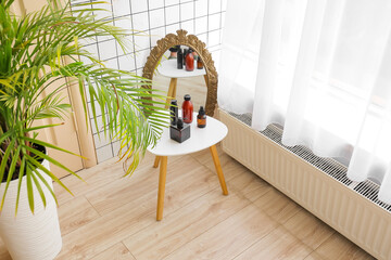 Fototapeta na wymiar Table with bottles of cosmetic products in bathroom