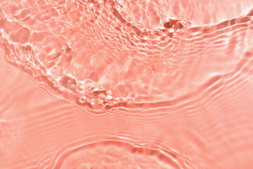 Texture of water with ripples on pink background, closeup