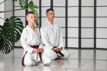 Boy and karate instructor in dojo