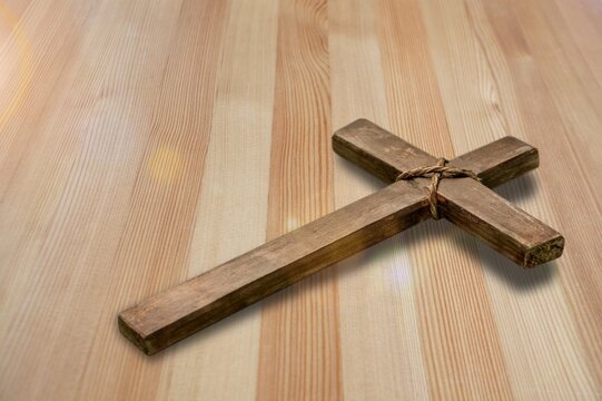 Religious wooden crucifix cross upright on wooden table background