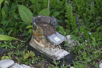 Garden planters shapped like boots and shoes and gardening equipment
