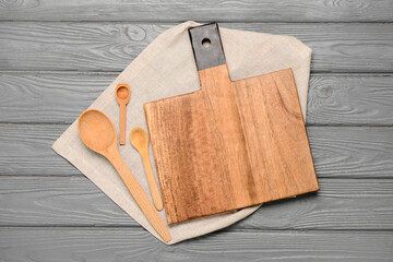 Fototapeta premium Cutting board and spoons on grey wooden background