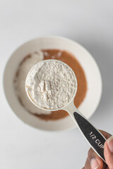 All purpose flour in a white measuring cup