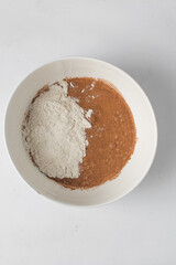Making pastry dough  in a white bowl, flour, sugar and cinnamon in a bowl
