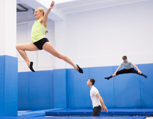Portrait of positive athletic girl during training in trampoline center. Sport lifestyle concept..