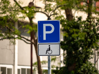 Disabled parking lot traffic sign. Street symbol with a wheelchair. Extra place to park a car for people that are handicapped. This place is the most accessible area to park a car.