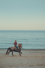 ride a horse at the beach at sunset