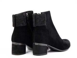 Women's autumn ankle black suede boots with black zip and average heels, isolated white background. Back side view. Fashion shoes.