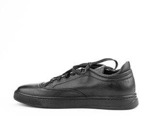 Black leather classic sneakers with laces. Casual men's style. Black rubber soles. Isolated close-up on white background. Left side view.