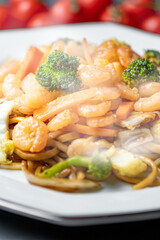 Fresh asian yakisoba shrimp in white dish.