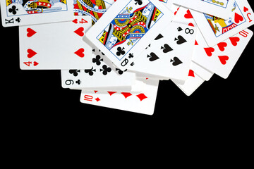 bunch of playing cards of different colors on a black background