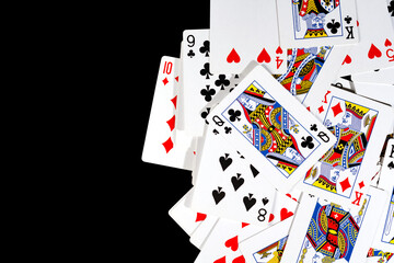 bunch of playing cards of different colors on a black background