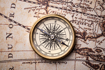 Old golden compass on the antique and vintage mundi map. 