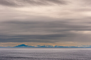 Pacific Coastline, Alaska, USA - July 16, 2011: Canadian Rocky mountains under heavy gray...