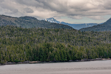 Pacific Coastline, Alaska, USA - July 16, 2011: Canadian Rocky snowy mountain top under heavy...