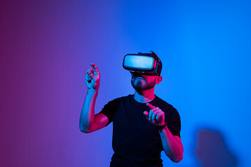Modern architect, designer using virtual reality glasses at workplace. Designer working in augmented reality vr studio. Man working in VR goggles on a studio background.