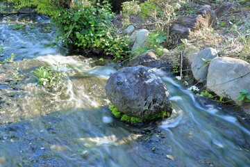 Naklejka na ściany i meble 川の流れを変える石