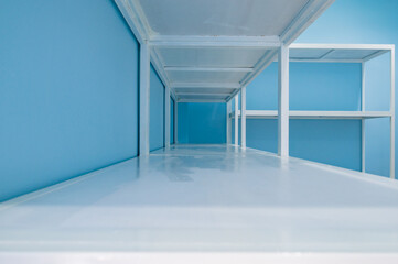 Empty white shelves in blue storage room