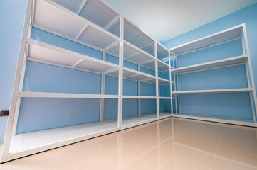 Empty white shelves in blue storage room