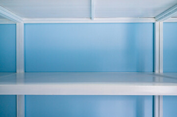 Fototapeta premium Empty white shelves in blue storage room