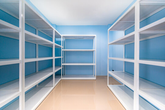 Empty White Shelves In Blue Storage Room