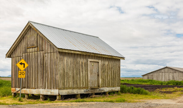 An old wooden barn in a farm in overcast day in Canada.