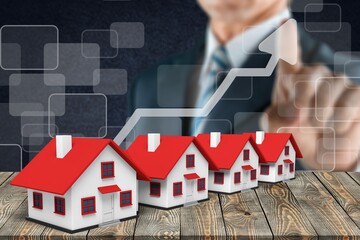 Businessman touch an arrow up over mini houses. The concept of increasing the cost of housing. Real estate concept.