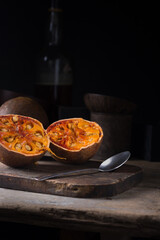 ripe bael fruit, also known as bengal quince, golden apple or stone apple, sweet aromatic, medicinal benefits fruit on table top with dark background, copy space