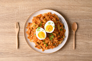 Korean kimchi fried rice with boiled egg on wooden table