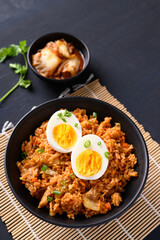 Korean kimchi fried rice with boiled egg on black background
