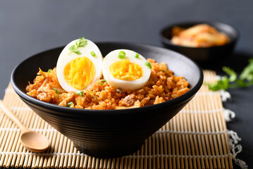 Korean kimchi fried rice with boiled egg on black background