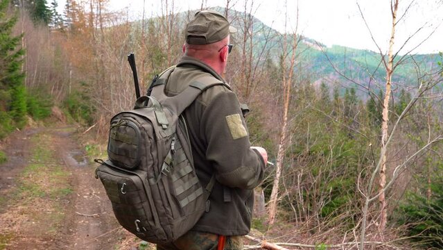 Old Hunter in the woods with his dog. Male hunter hunting with his hunting dog outdoors. German wirehaired pointer. Hunter with his shotgun in middle of nature.