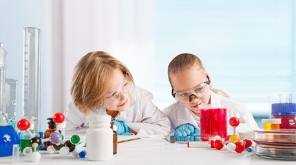 Obraz na płótnie Canvas Excited Kid conducting a scientific experiment or chemical reaction at chemistry laboratory