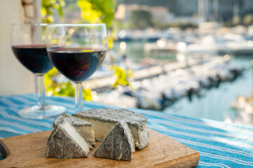 Summer party with red wine and cheeses on outdoor terrace with view on old fisherman's harbour with...