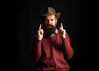 Funny cowboy man in cowboy hat. Wild west guns, finger revolver shooting. Cowboy man point fingers...