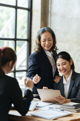 Group of young business people working and communicating while sitting at the office desk together, Successful business team sitting in office and planning work.