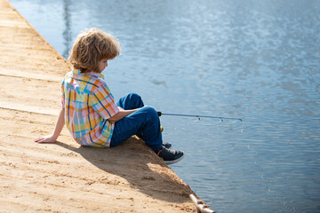 Child fishing at river or lake. Young kid fisher. Summer outdoor leisure activity. Little boy angling at river with rod.