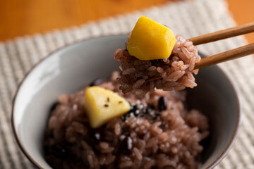 栗赤飯を箸で持ち上げる