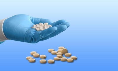 Medical background. Hand holds one of many capsule tablets or pills. Healthcare pharmacy and medicine concept